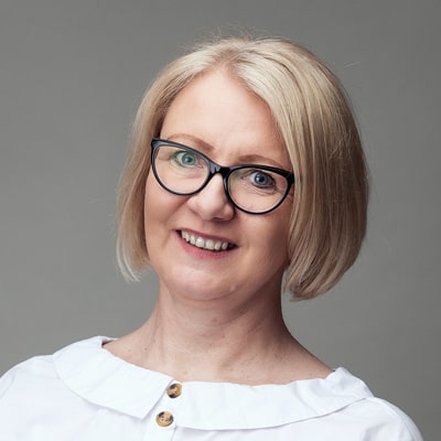 zdjęcie portretowe kobiety z krótkimi blond włosami, w ciemnych okrągłych okularach