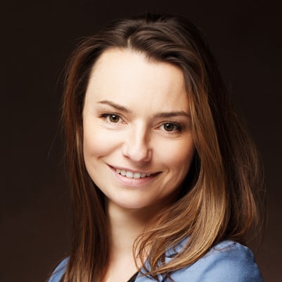 Młoda kobita o kasztanowych włosach uśmiecha się