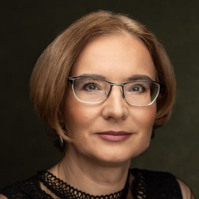 Izabella Wójcik zdjęcie portretowe szczupłej kobiety w okularach, z brązowymi włosami średniej długości