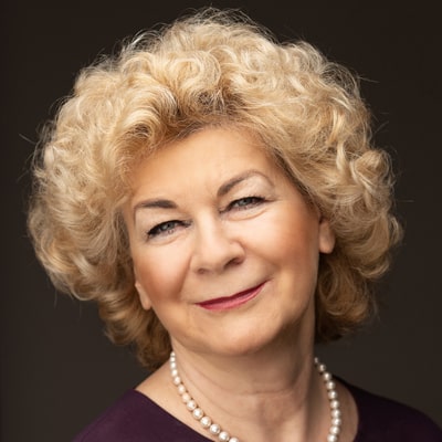 Elżbieta Krzyżanowska zdjęcie portretowe uśmiechnietej kobiety, z jasnymi bujnymi włosami