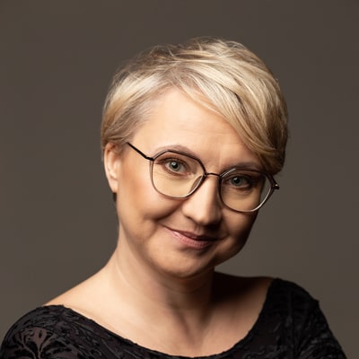 Beata Bobińska zdjęcie portretowe uśmiechnietej kobiety w okularach, w krótkich, jasnych włosach