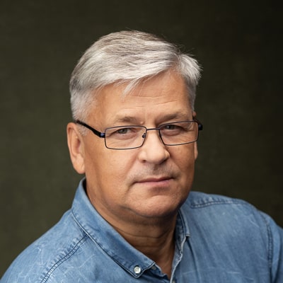 Krzysztof Rak zdjęcie portretowe mężczyzny w średnim wieku, w okularach, z jasnymi włosami
