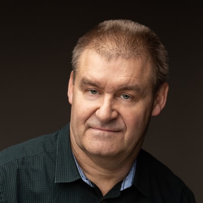 Mariusz Regosz zdjęcie portretowe mężczyzny w średnim wieku, w ciemnej koszuli