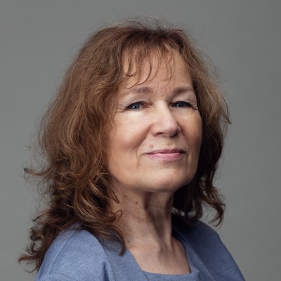 zdjęcie portretowe uśmiechniętej kobiety z długimi, brązowymi włosami