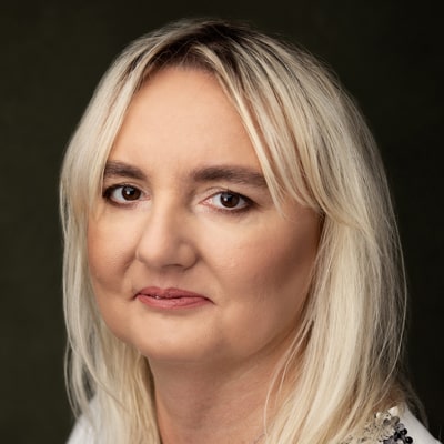 Beata Styś zdjęcie portretowe kobiety w średnim wieku, z długimi jasnymi włosami i ciemnymi oczami