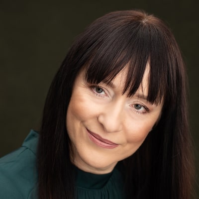 Justyna Mielczarek zdjęcie portretowe uśmiechnietej kobiety, z długimi ciemnymi włosami