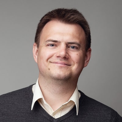 zdjęcie portretowe mężczyzny z sympatycznym uśmiechem, w brązowych, równo ułożonych włosach
