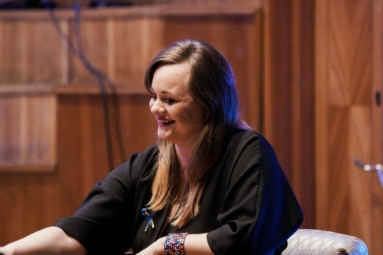 uśmiechnięta kobieta, siedzi na fotelu, konferansjerka podczas koncertu dla młodzieży