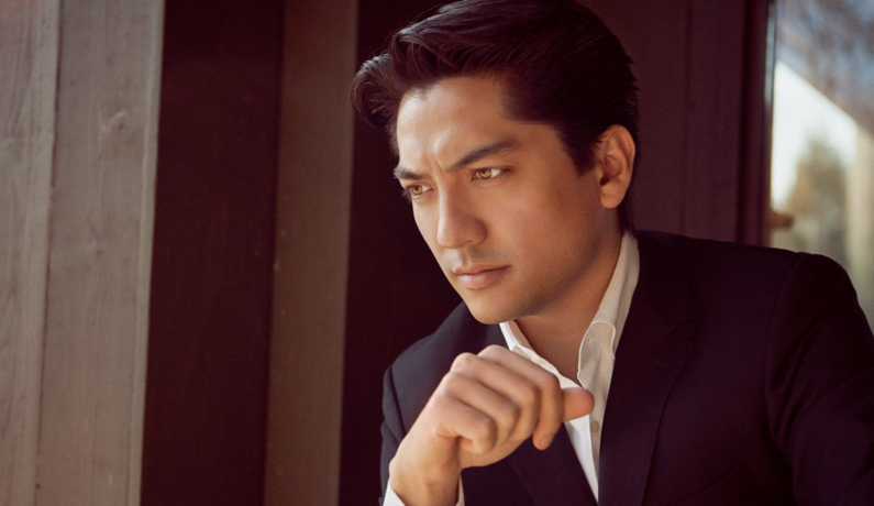 zdjęcie mężczyzny podbierającego się na łokciu, patrzącego w dal