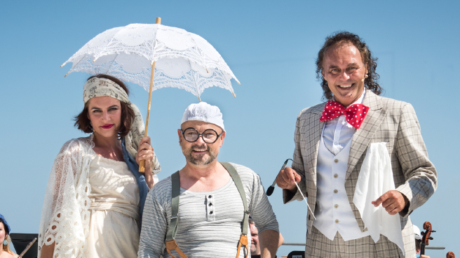 zdjęcie trzech osób w jasnych, śmiesznych przebraniach