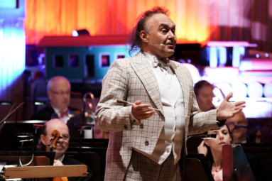 zdjęcie dyrygenta w jasnym fraku w kratę