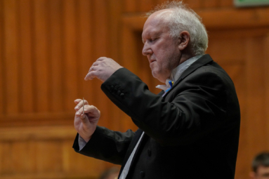 zdjęcie dyrygenta z zamkniętymi oczami wsłuchującego się w muzykę