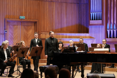 zdjęcie estrady, na którą wchodzi Krzysztof Herdzin, Paweł Kapuła i siedzą muzycy Capelli Bydgostiensis