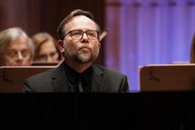 zdjęcie mężczyzny w średnim wieku siedzącego za fortepianem