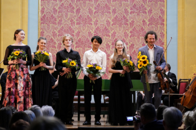 zdjęcie solistów na estradzie, z kwiatami w rękach