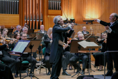 zdjęcie Vadima Brodskiego wraz z dyrygentem i orkiestrą symfoniczną