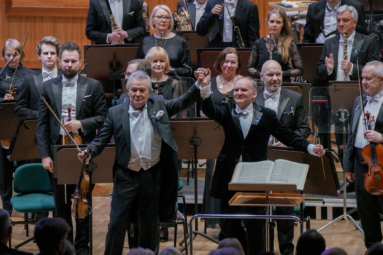 zdjęcie Vadima Brodskiego i Raoula Grüneisa odwróconych twarzą do publiczności, trzymających się za ręce uniesione w górze