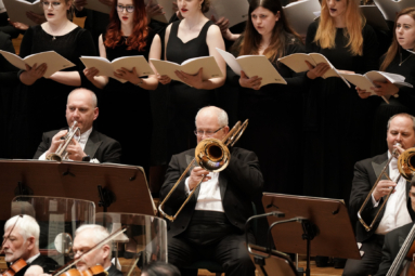 zdjęcie puzonistów i trębacza grających na instrumentach w trakcie koncertu