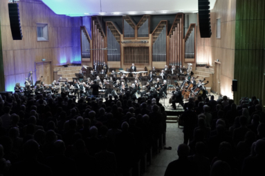 zdjęcie orkiestry symfonicznej na estradzie oraz publiczności