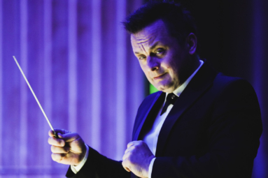 zdjęcie dyrygenta zerkającego w stronę orkeistry