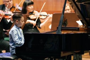 zdjęcie młodego pianisty grającego koncert na fortepianie