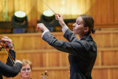 zdjęcie dyrygentki z uniesionymi rękami
