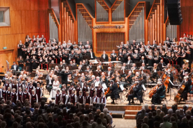 zdjęcie estrady, na której znajduje się ogromny aparat wykonawczy: orkiestra symfoniczna, cztery chóry, soliści