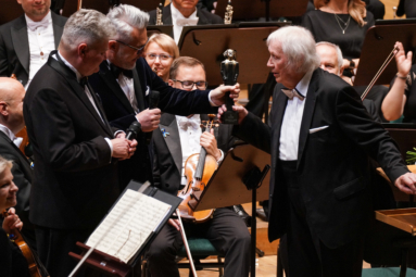 zdjęcie dyrektorów FP wręczających dyrygentowi na estradzie statuetkę Ignacego Jana Honorowego