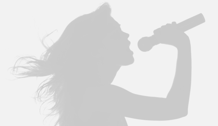 Sylwetka kobiety z rozwianymi włosami, w prawej dłoni trzyma mikrofon