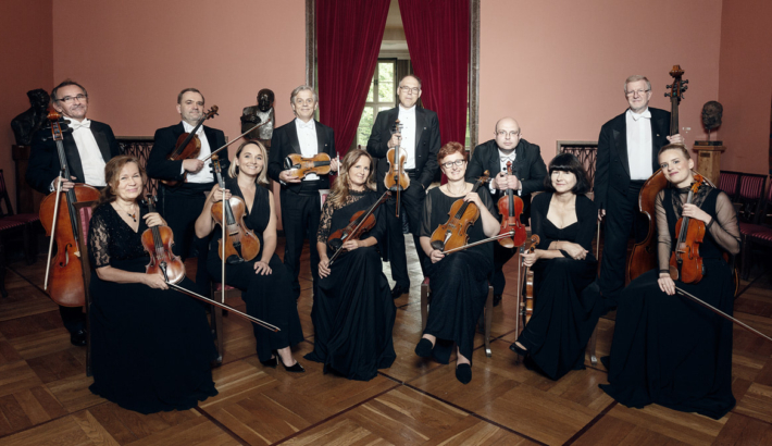 Grupa muzyków, trzymając instrumenty pozuje do zdjęcia