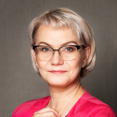 zdjęcie portretowe drobnej kobiety o krótkich, jasnych włosach, w półokrągłych dużych okularach