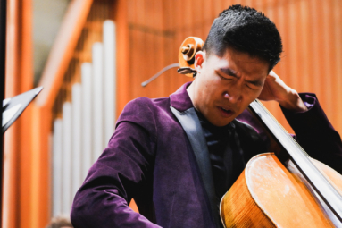 zdjęcie młodego mężczyzny o azjatyckich rysach twarzy grającego na wiolonczeli