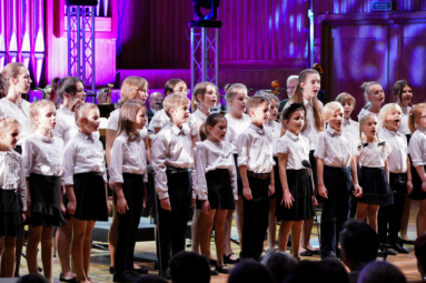 zdjęcie chóru dziecięcego ubranego w białe bluzki, siewającego wspólną piosenkę