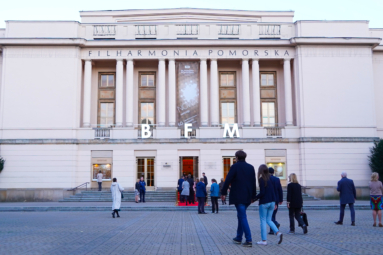 Gmach Filharmonii Pomorskiej z szyldem festiwalu w okiennicach i czerwonym dywanem na schodach