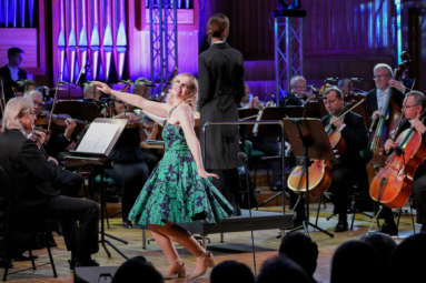 zdjęcie śpiewaczki wykonującej obrót z radosnym uśmiechem na twarzy