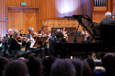 zdjęcie pianisty przy fortepianie i muzyków orkiestry symfonicznej FP grających na skrzypcach