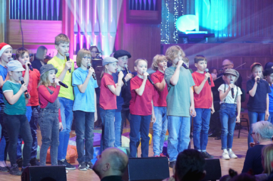 zdjęcie dzieci przebranych za uczniów Akademii Pana Kleksa, śpiewających do mikrofonu