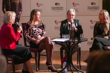 Zdjęcie czterech kobiet rozmawiających przy małym drewnianym stoliku