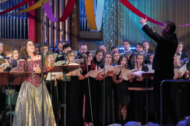 zdjęcie chóru, dyrygenta i solistki podczas wykonywania kolęd na estradzie FP