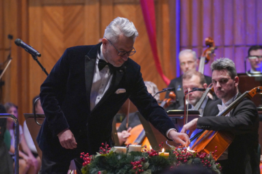 zdjęcie dyrektora FP zapalającego świeczkę przy wieńcu adwentowym