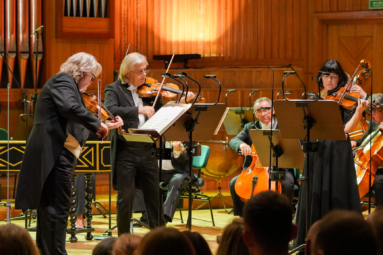 zdjęcie trzech skrzypków: dwóch mężczyzn i kobiety, grających wspólny koncert