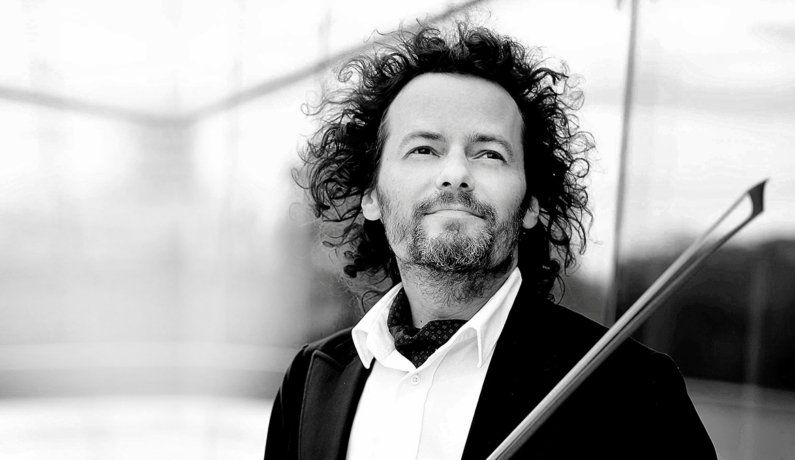 portret mężczyzny w kręconych włosach spoglądającego z zadumą w górę