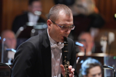 zdjęcie mężczyzny w krótkich włosach i okularach grającego na klarnecie