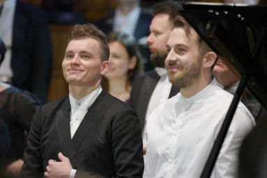 zdjęcie dwóch młodych mężczyzn uśmiechających się do publiczności