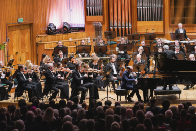 orkiestra symfoniczna oraz pianista podczas koncertu na estradzie