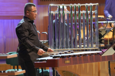 zdjęcie perkusisty o azjatyckich rysach twarzy grającego na marimbie