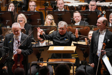 zdjęcie trzech mężczyzn: dwóch altowiolistów i dyrygenta zwróconego do publiczności