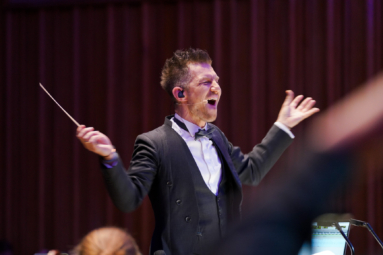 zdjęcie dyrygenta z uniesionymi rękami