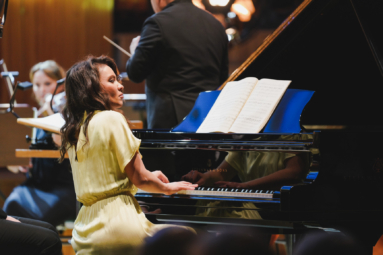 zdjęcie pianistki w żółtej sukience grającej na fortepianie