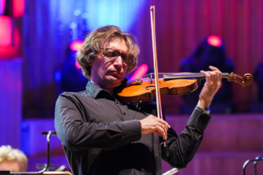 zdjęcie skrzypka w dłuższych włosach, grającego z zamkniętymi oczami